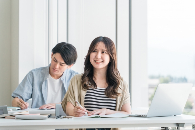 机で勉強する女性と男性