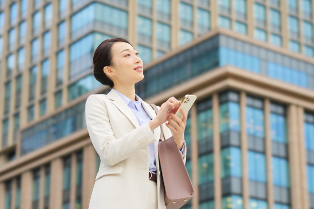 スマホを片手にして探す女性